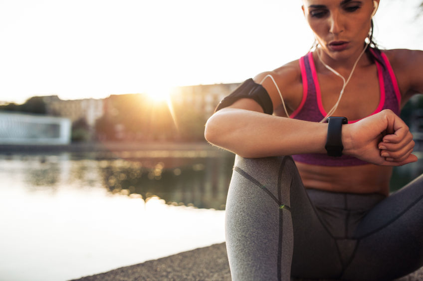 runner checking her performance on fitness smart watch device