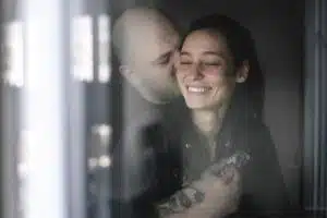 couple amoureux derriere la vitre de la chambre dhotel