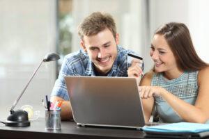 couple comparing products buying on line with a laptop